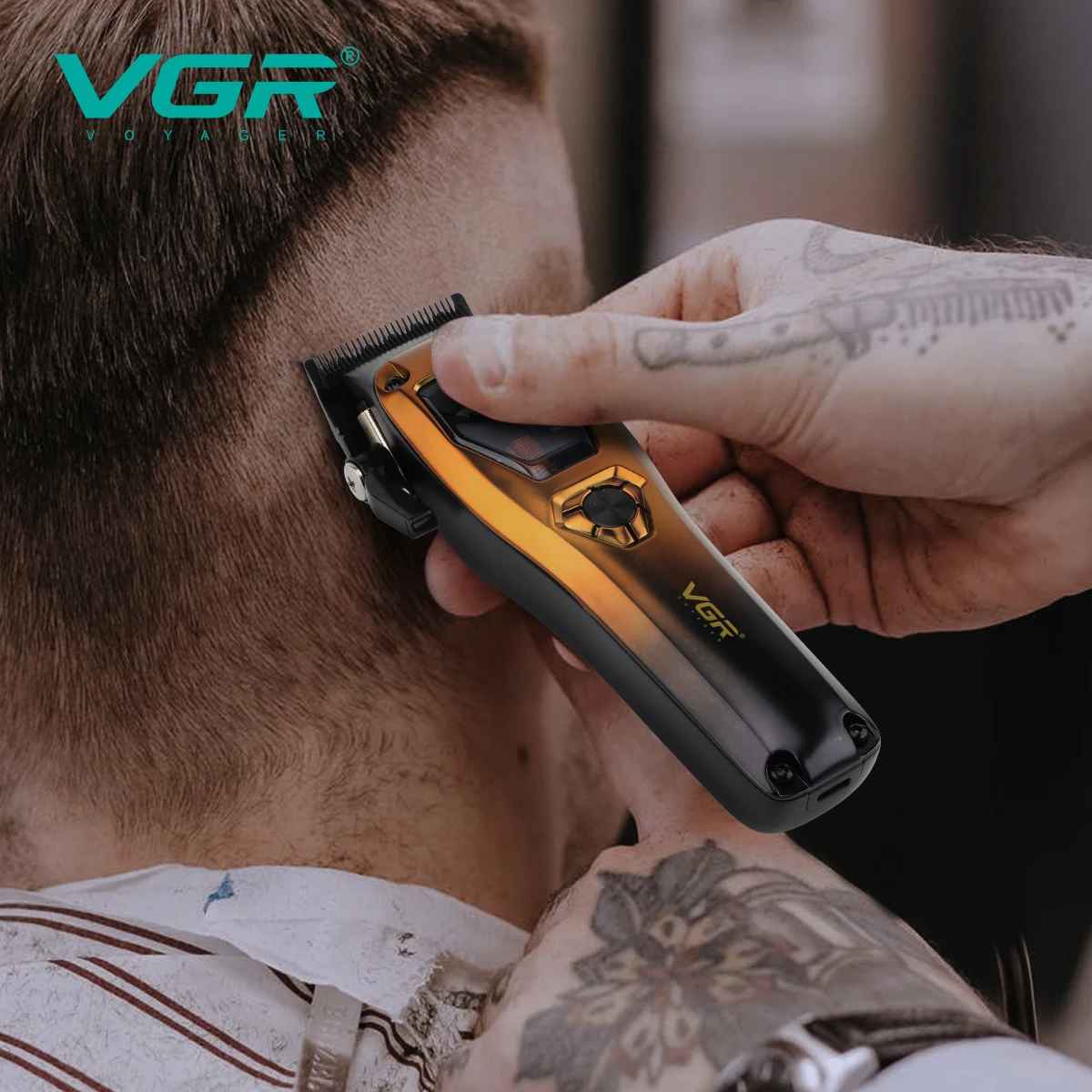 Close-up view of a tattooed barber's hands precisely operating the gold and black VGR Voyager hair clipper to trim the short hair on the back of a client's neck.