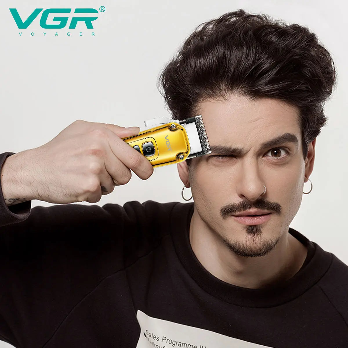 Close-up of a man using the VGR V-006 gold professional hair clipper to detail sideburns and face, showing precise cutting capability.