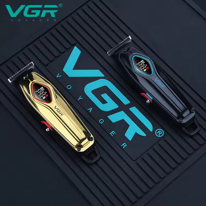top down professional view of the vgr v-945 gold and black hair cutting machines placed on a black branded vgr voyager rubber barber work mat showing side power lever switches and precision t blades