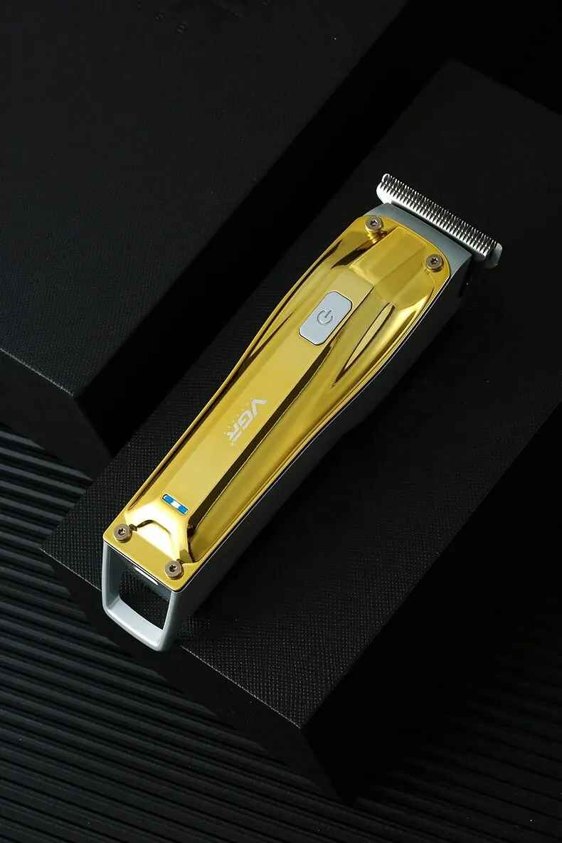 a high-angle lifestyle shot of the golden metallic vgr v-955 professional beard and hair trimmer resting on a dark, sleek platform.