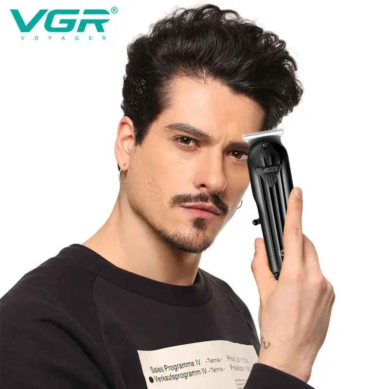 Model holding the ergonomic VGR V-982 black hair trimmer near his head, demonstrating precise beard and hairline styling capability.